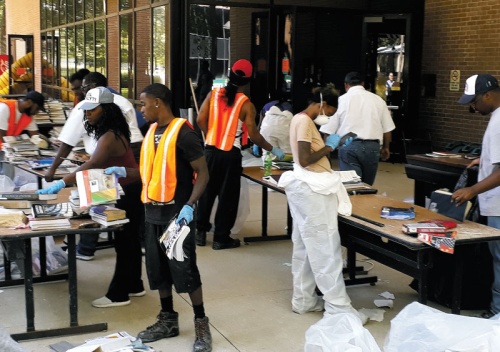 Employees from a restoration company clear out LSC-Kingwoodu2019s library after the school took on several inches of water following Hurricane Harvey. 