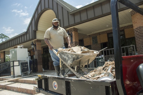 Mercer Botanic Gardens workers clean debris from the flooded visitor center.