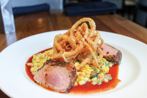 Wood-grilled pork tenderloin ($28) is served with jalapeno-charred corn and Texas peach barbecue sauce.