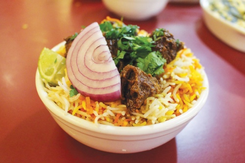 Goat Fry Biryani ($15.99) Goat meat is pan-fried with a special sauce and served on biryani rice with purple onion, cilantro and a lime wedge.  