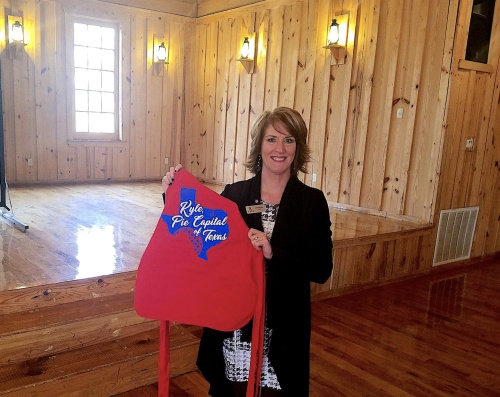 Julie Snyder, CEO of the Kyle Area Chamber of Commerce, holds an apron with one of Kyle's potential new logos. 