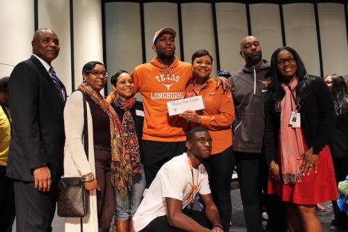 Dekaney High School senior Malcolm Epps, center, poses for a celebratory photo after signing his letter of intent to play for the University of Texas Longhorns following graduation this spring.