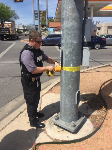 A police officer puts up yellow tape to close Railroad Avenue to traffic in downtown Pflugerville near the home of the Austin bombing suspect.