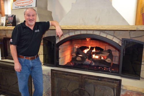 Sales Manager Steve Romero stands by an outdoor fireplace display