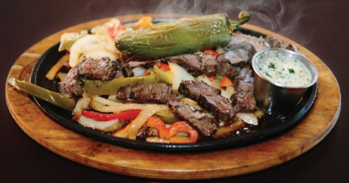Beef fajitas ($18.99 or $34.99) come with grilled peppers and onions, guacamole, pico de gallo and sour cream. 