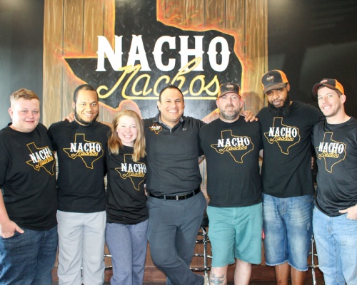 Owner Chris Gonzalez (center) stands with some of his team members at Nacho Nachos. Gonzalez said his brick-and-mortar location is one of several he hopes to have in the Greater Houston area. 
