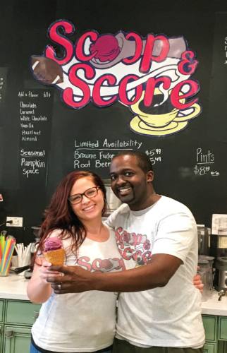 Alex and Angela Ellis hold out two scoops of Graeteru2019s Black Raspberry Chocolate Chip ice cream.