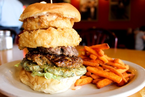 The Triple Decker Burger ($11.29) features jalapeno chicken, pork and beef pattiesu2014all stacked together with onion rings, cheese and lettuce.