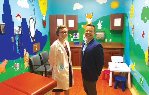 Dr. Emily Fisher and Thien Nguyen stand in a decorated room at the Circle C clinic. 
