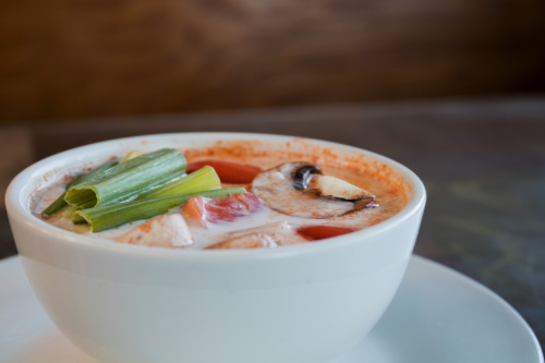 Tom Kha soup is served with mushrooms, galangal, lemongrass, onions, tomatoes and kaffir leaves with a choice of chicken, tofu, or vegetable for a bowl ($6) or pot ($11). Shrimp is an extra $2.
