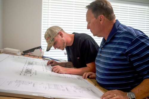 Jack Williams, right, and his son, Wyatt, survey designs from one of JT Williams Masonryu2019s ongoing projects. The Williamses keep family in the business, with their daughter and son-in-law employed by the masonry company.