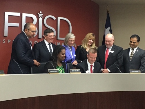 FBISD trustees gather as board President Jason Burdine signs the approval for the 2018 bond election.