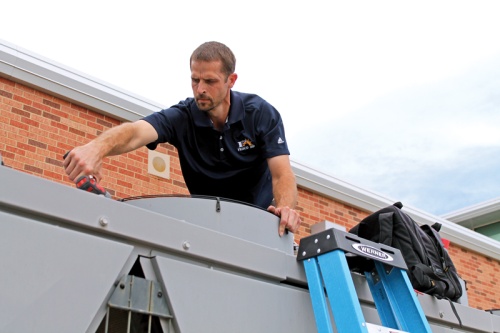 A Frisco ISD maintenance employee works on the air system at Christie Elementary School.