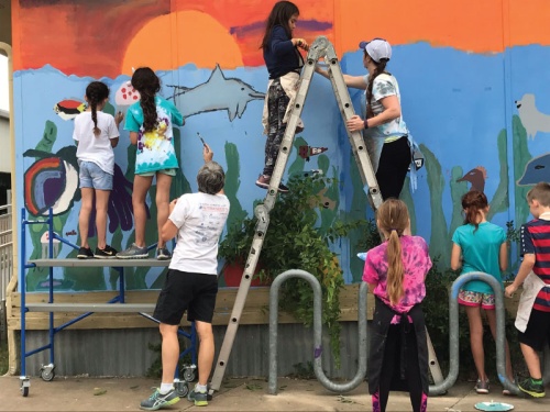 Students from Davis Elementary School paint a science-themed mural on a portable classroom in May. 