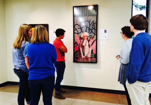 Students at The Woodlands High School work together to curate art pieces that hang in the school hallways.