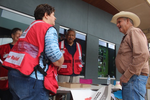 Red Cross volunteers assist Travis County resident Dewey Cooper Tuesday at the Lake Travis Community Library. 