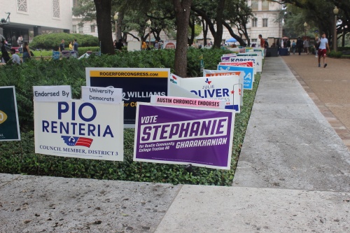 Signs crowded the green space outside of the Flawn Academic Center, one of two polling stations on UT-Austin's campus.
