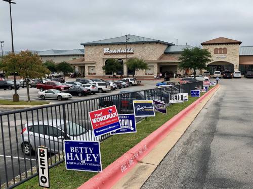 Political signs line the entrance of the Lakeway Randall's, one of the Lake Travis-Westlake area's voter locations.