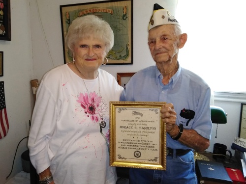 Karen Thompson, chair of the Leander Historical Preservation Commission, hands a certificate of appreciation to Horace Hamilton, a World War II veteran and Pearl Harbor survivor.