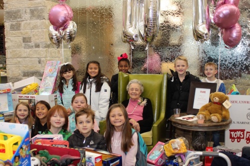 Second-graders deliver 202 toys to Gladys McLean in honor of her 101st birthday, doubling her wish for one toy for every year of her life.
