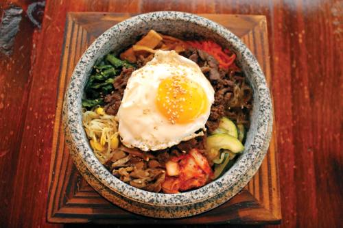The hot stone bowl, shown here with bulgogi, is placed over a fire to help crisp the rice at the bottom and keep the toppings and meat warm.