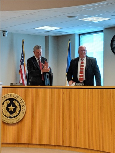 Montgomery County Judge Craig Doyal (left) is celebrated by Precinct 2 Commissioner Charlie Riley and other county officials and staff at the last Montgomery County Commissioners Court of 2018.
