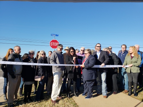 Michaela Dollar (center), director of economic development for the City of Georgetown, cuts the ribbon at the Airport Road expansion project on Jan. 4, 2019. 