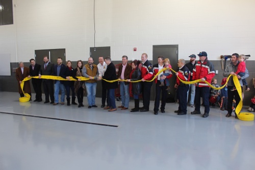 City Council members and city staff separate a fire hose to mark the grand opening of Leander's Fire Station No. 1.