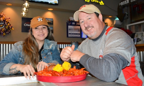 Danielle Smith and Greg Doulin sample some crawfish at one of their restaurantu2019s custom crawfish tables.