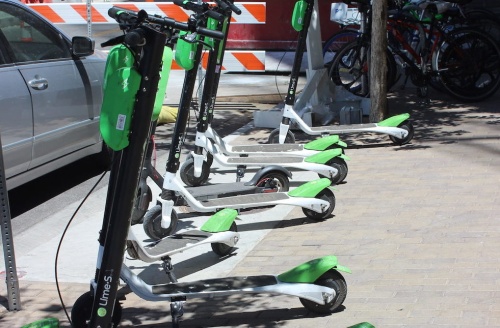 Lime scooters line a sidewalk in Austin. 