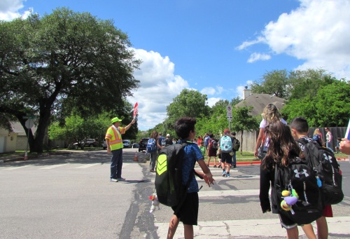 Students from Baranoff Elementary School in South Austin head home April 18, crossing Gatling Gun Lane.