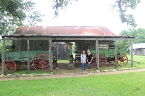 Director of Marketing and Events Jenny Pack (left) and Director of Museum Operations Liz Lubrani stand in front of the Poundsu2019 barn and wagon.