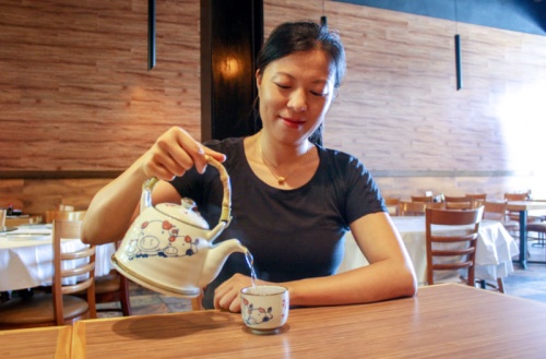 Hunan Kitchen owner Chen Liu pours jasmine tea at the restaurant on Katy Freeway.