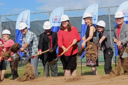 Trustee Yasmin Wagner (center) and Bowie High School Principal Mark Robinson (left of center) break ground with other school officials June 6. 