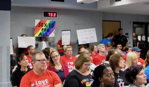 Austin ISD residents hold up signs both supporting and opposing proposed changes to the district's sexual education curriculum. 