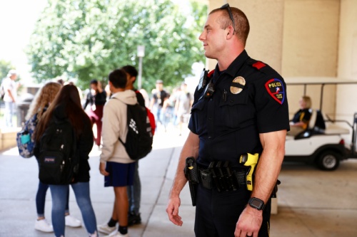 School Resource Officer Troy Bourgeois watches over students during a passing period at Plano East Senior High School. Bourgeois is one of 25 current SROs from Plano Police Department.