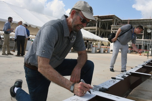 Tom Jackson signs the final beam for Middle School No. 19 during a u201ctopping ceremonyu201d on July 30. 