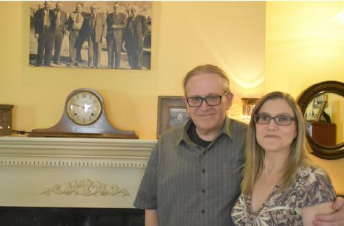 Renfro and Sandy Lesley stand next a photo they restored of Renfrou2019s family.