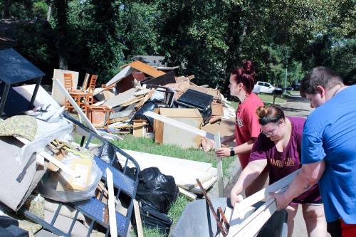 Kaleigh Murski (left), Ashleigh Dehnert (center)  and Nick Grimes (left) piled debris on the curbside of Grimes' Elm Grove home.