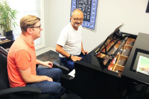 Piano teacher Jim James (left) gives a lesson to student Sid Chaterjee in his lesson room at the West Lake Hills location.